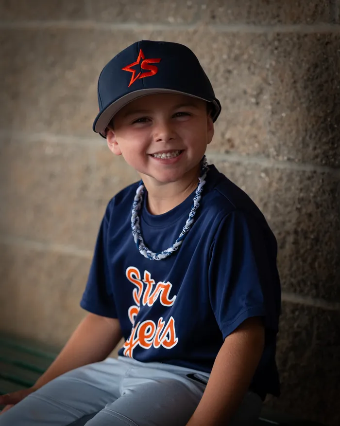 Star Tigers youth baseball player grinning on the dugout bench, Star Idaho