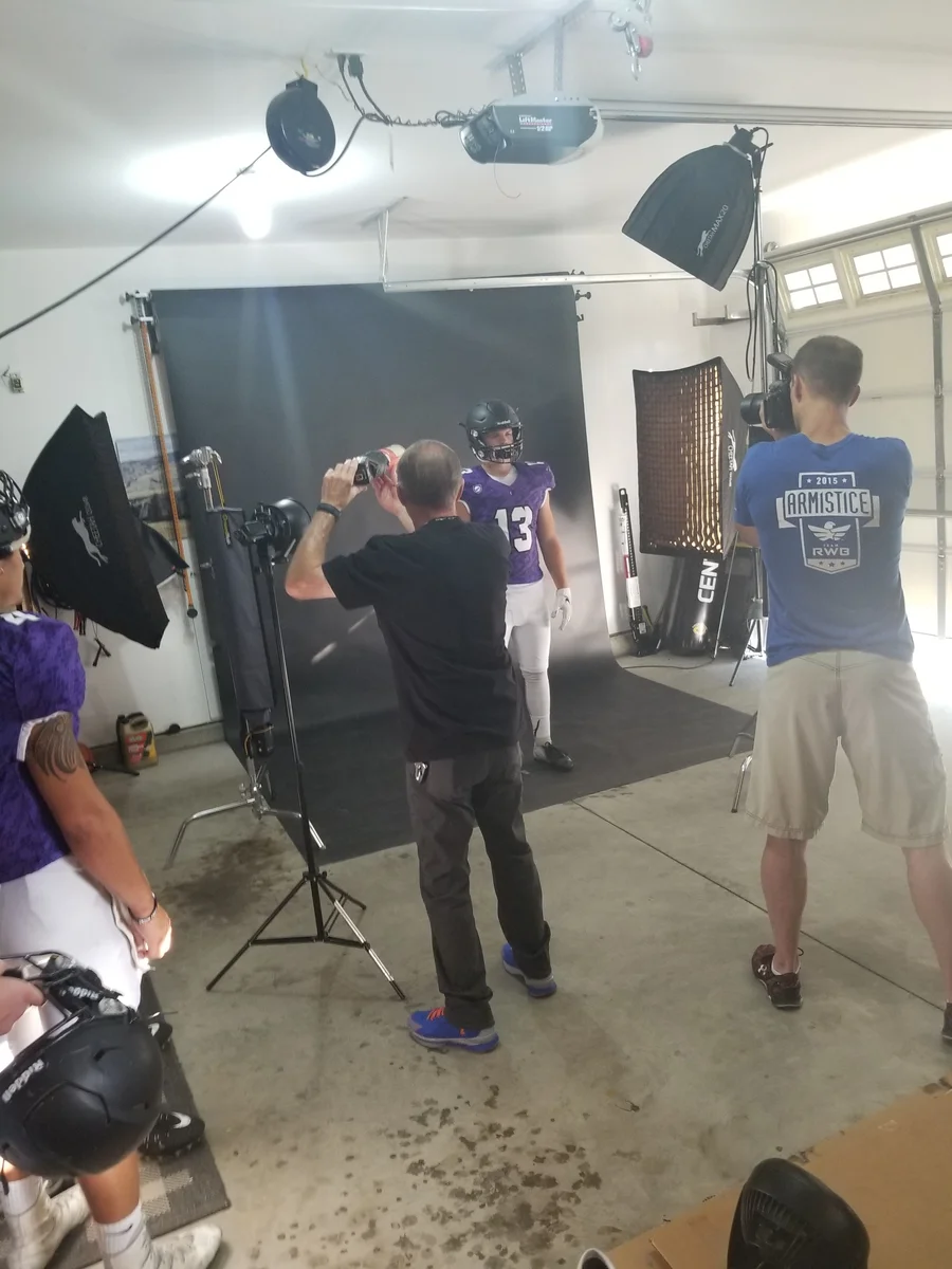 Mark Rezansoff shooting an individual football portrait in his garage studio in Meridian Idaho 2018 — the early days of Shooting Trio Photography