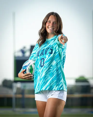 Addyson Crumley #0 waist up, ball under her arm, pointing at the camera