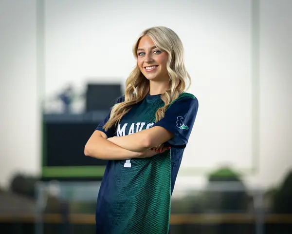 Horizontal frame of Jaci Anderson #7 from the waist up, arms crossed, smiling