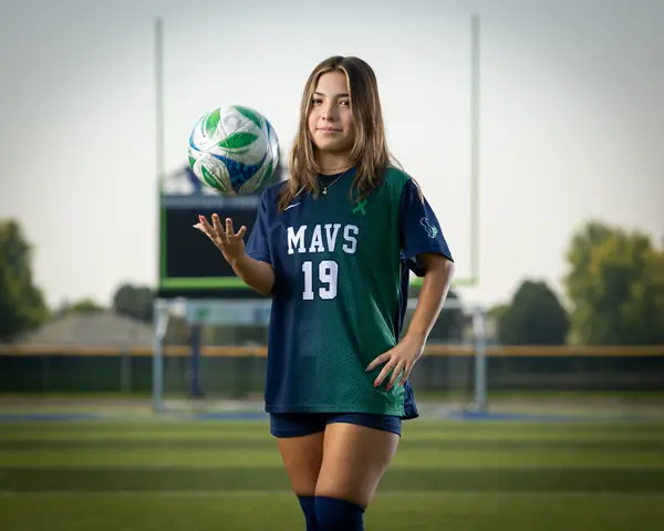 Maria Rojas #19 tossing the ball in the air with a hand on her hip
