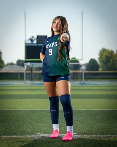 Vivian Sipe #9 full length, pointing at the camera in pink cleats