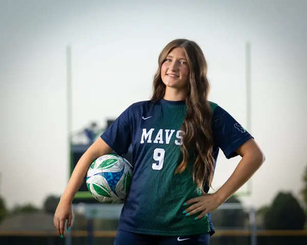 Vivian Sipe #9 from the waist up, ball under her arm and a hand on her hip