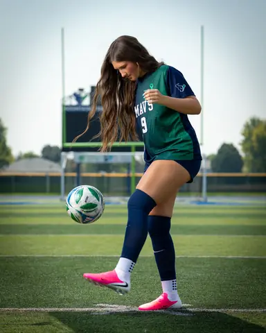 Vivian Sipe #9 full length in pink cleats, juggling the ball off her foot, eyes on the ball