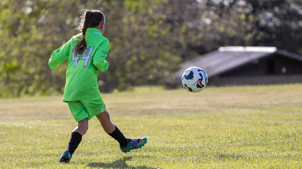 Parent sitting with child after youth sports loss, offering calm presence