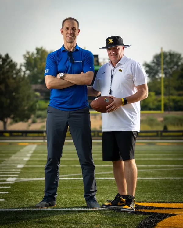 Mark Rezansoff of Shooting Trio Photography with Bishop Kelly head football coach Chris Culig on the BK football field, Boise Idaho, 2026