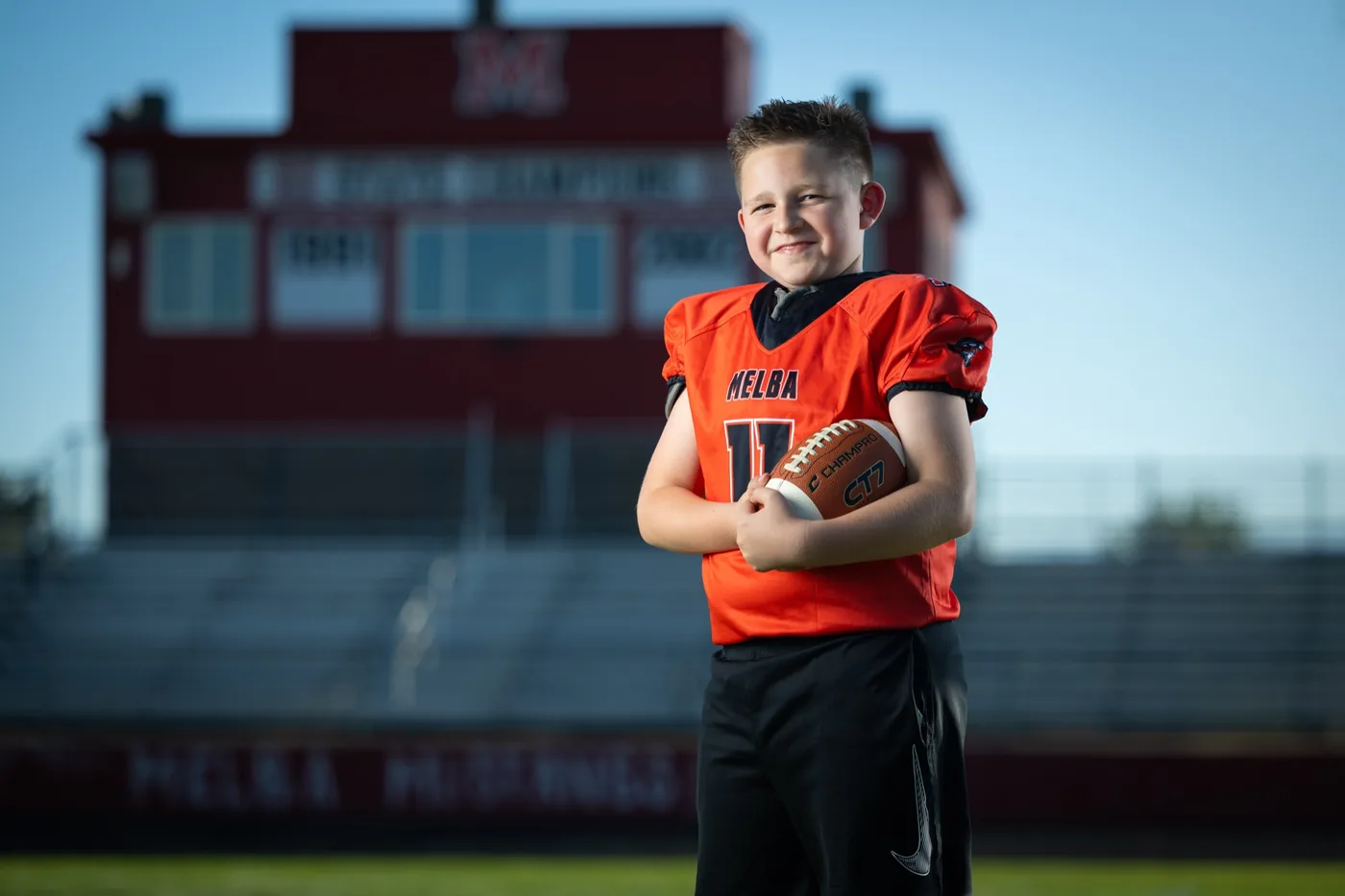 Melba Kuna Optimist flag football player portrait holding a football at the Melba High School field Melba Idaho