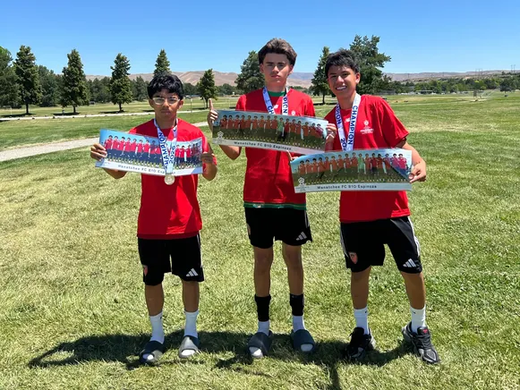 Three Wenatchee FC players holding their panoramic team prints after winning the Northwest President's Cup qualifier in Boise