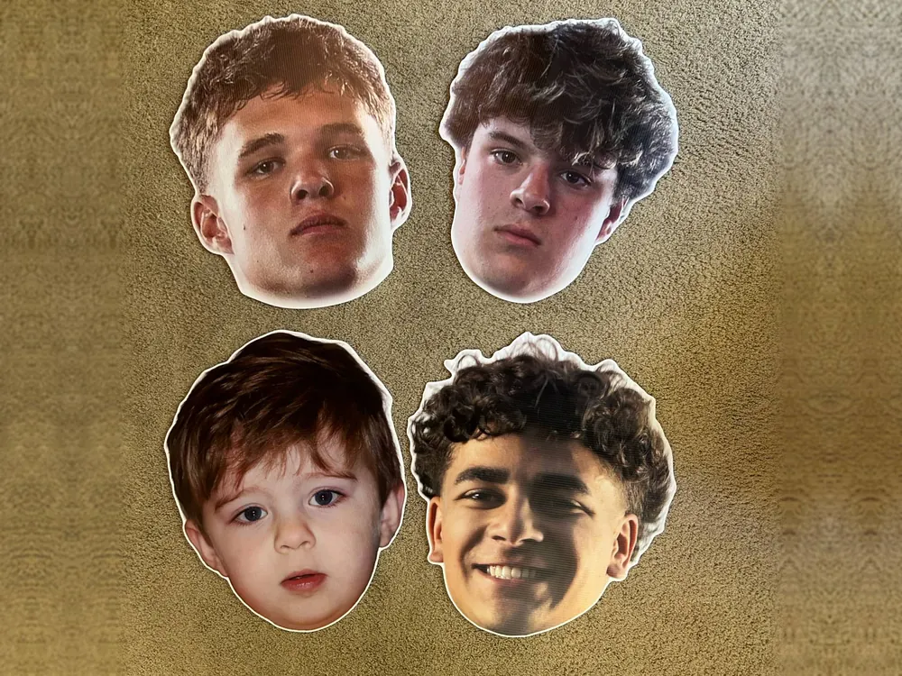 Four printed big head cutouts: three high school athletes and a toddler, die-cut on weatherproof board with a white border