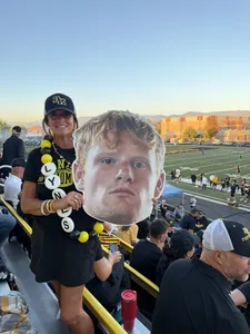 Bishop Kelly team mom Michelle Lynes holding a big head cutout in the stands
