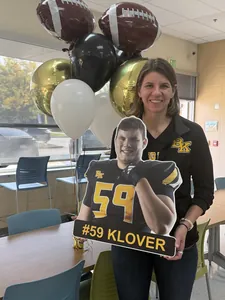 Bishop Kelly football parent holding a die-cut #59 player sign
