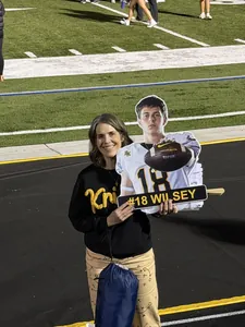 Bishop Kelly football fan on the sideline with a die-cut #18 player sign