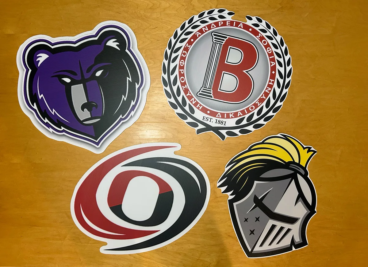 Four giant die-cut school logo cutouts printed on weatherproof board, about 20 inches each